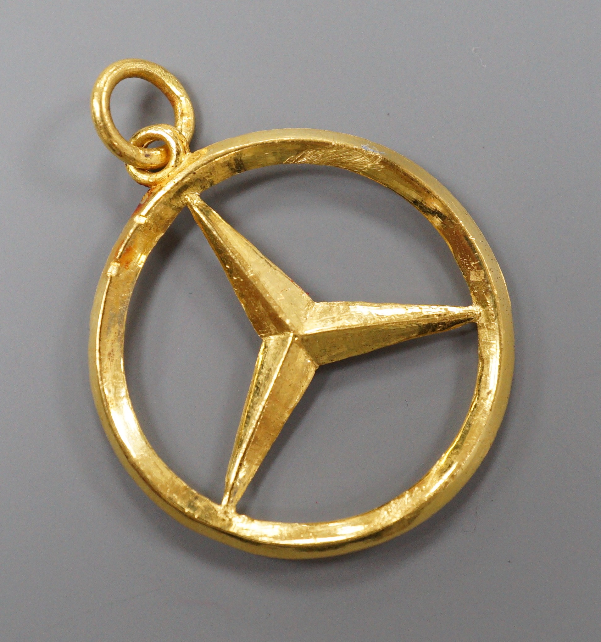 A modern Hong Kong yellow metal Mercedes Benz car badge pendant, 29mm, 8.5 grams.